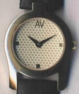 Specimen consisting of a photograph showing a watch face featuring a repeating pattern of the letters A and V.